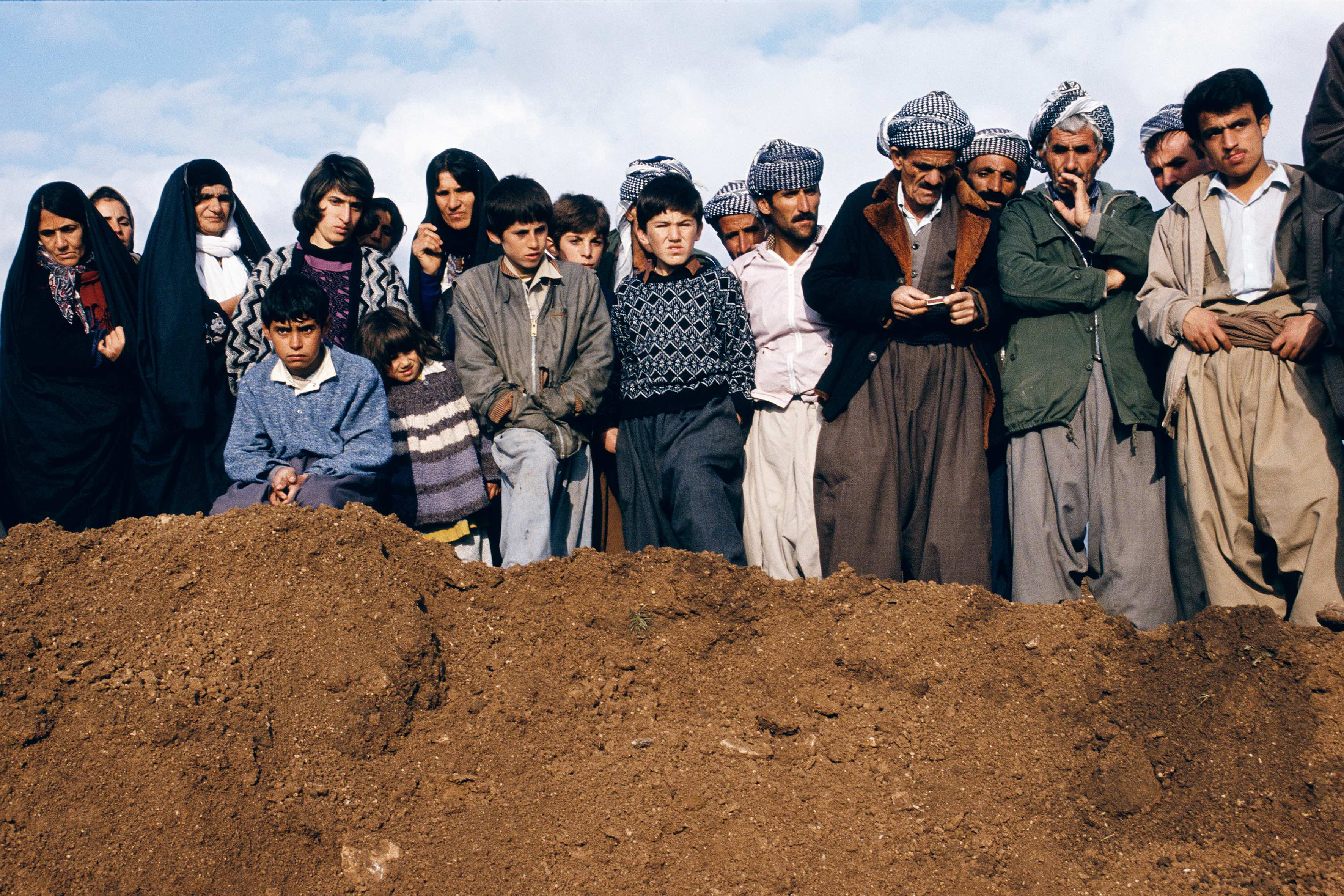 Susan Meiselas. Villagers watch exhumation at a former Iraqi military headquarters outside Sulaymaniyah, Northern Iraq, 1991 © Susan Meiselas