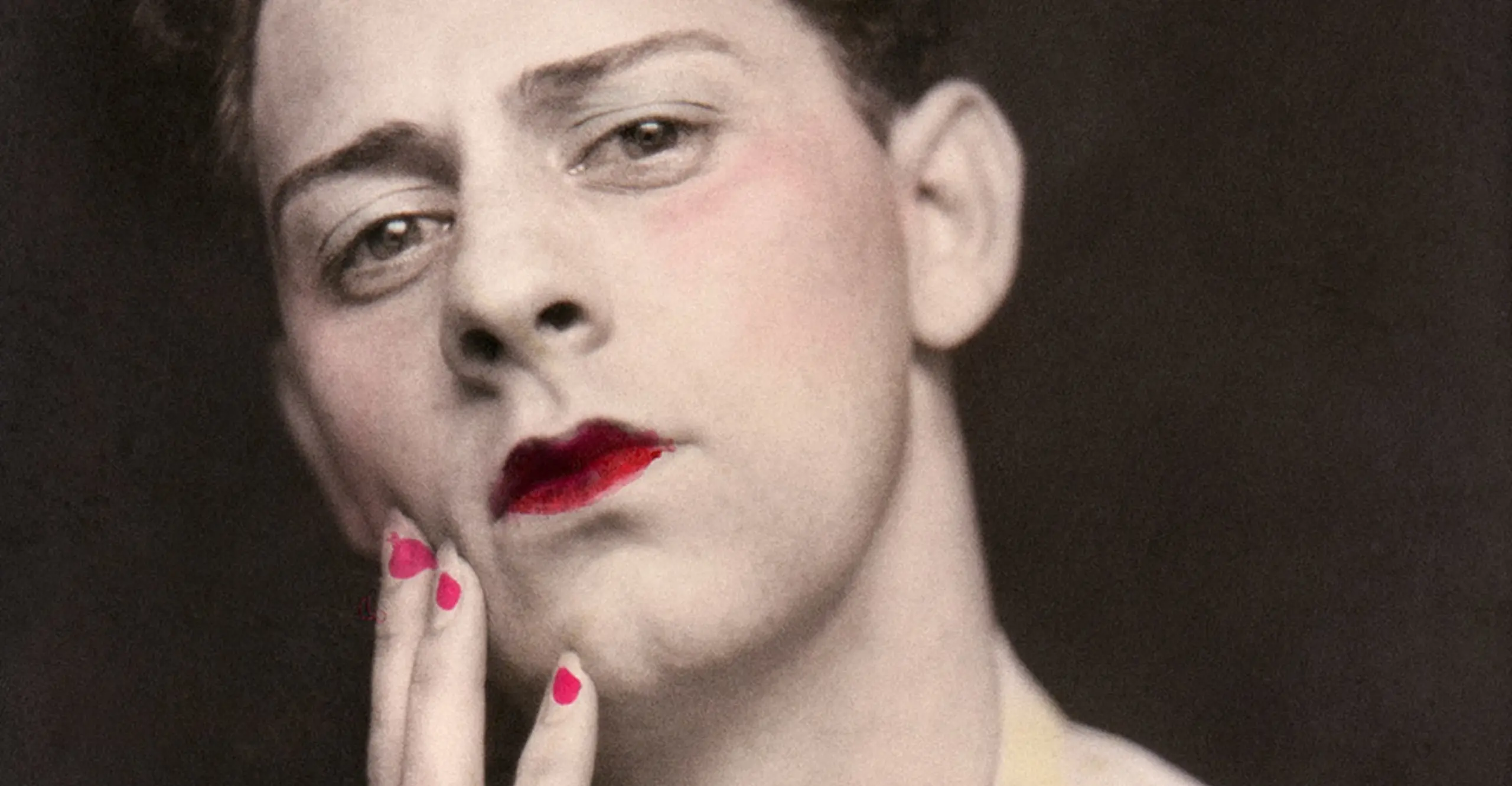 Man in makeup wearing ring. Photograph from a photo booth, with highlights of color. United States, circa 1920.  © Sebastian Lifshitz Collection  Courtesy of Sebastian Lifshitz and The Photographers’ Gallery