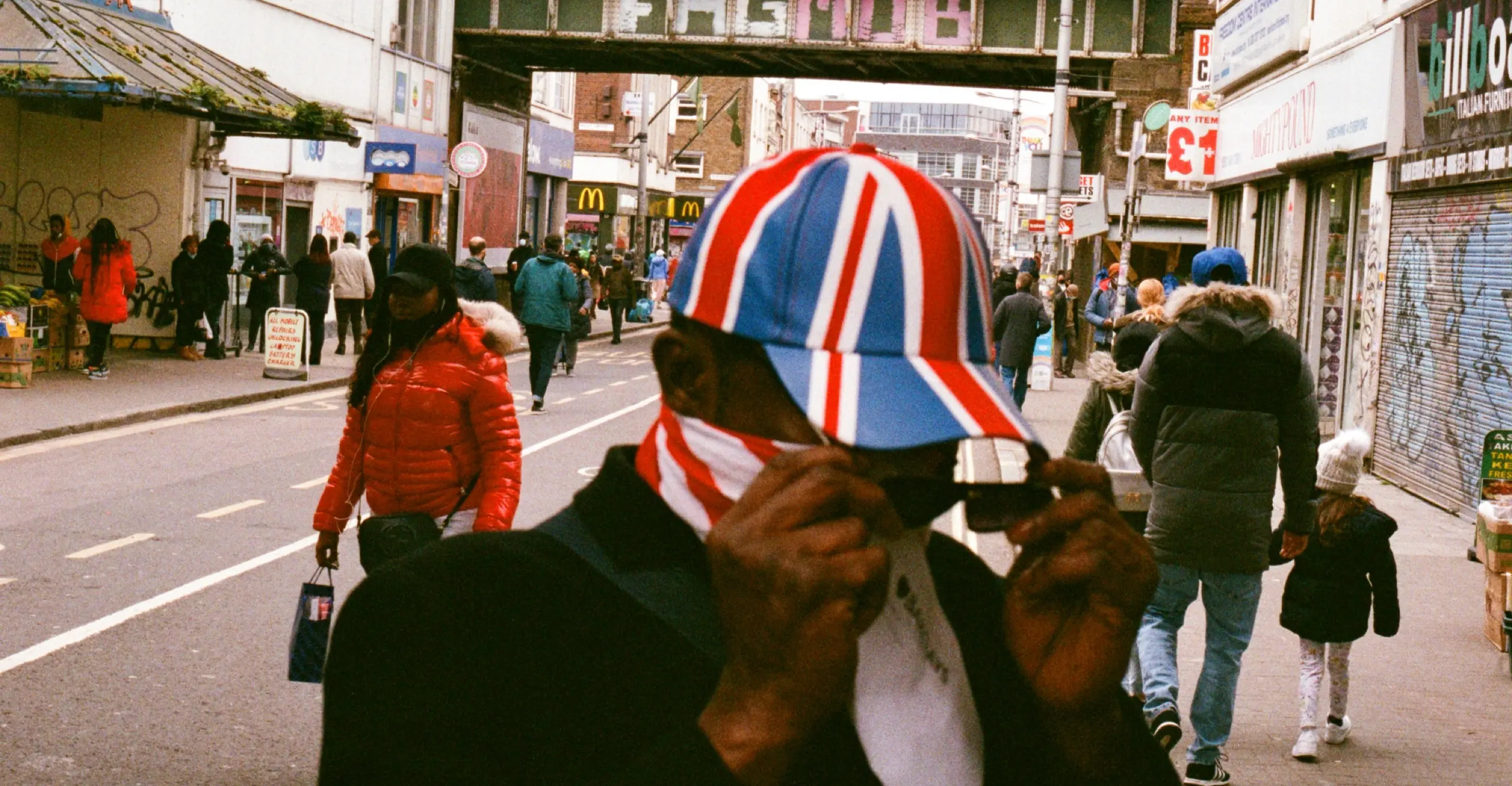 Image of a person wearing a Union Jack hat on a street in Peckham