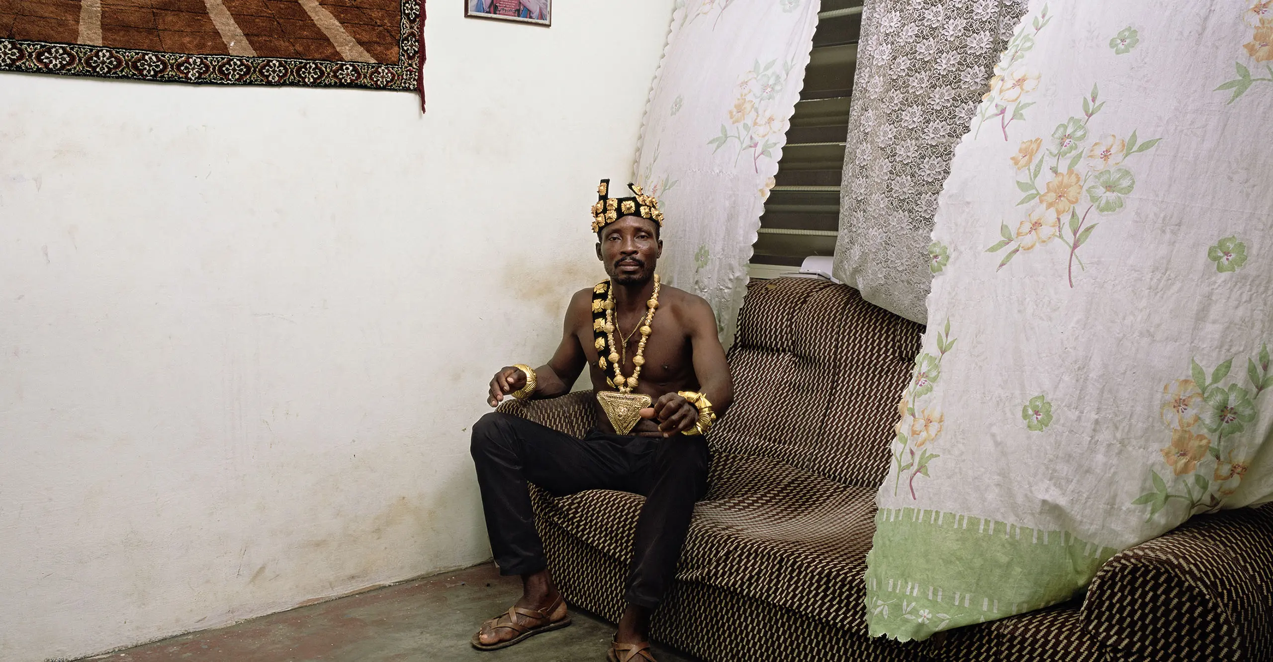 Man sitting on a sofa wearing a crown