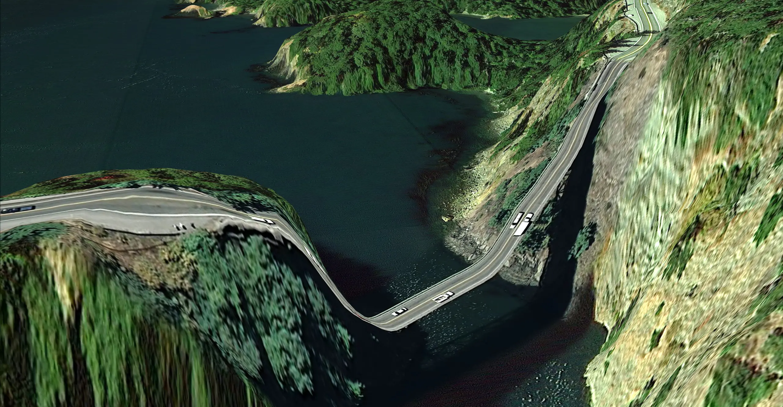 A stretched, low resolution view from a Google satellite of a road between two mountains, that curves unsupported over the sea