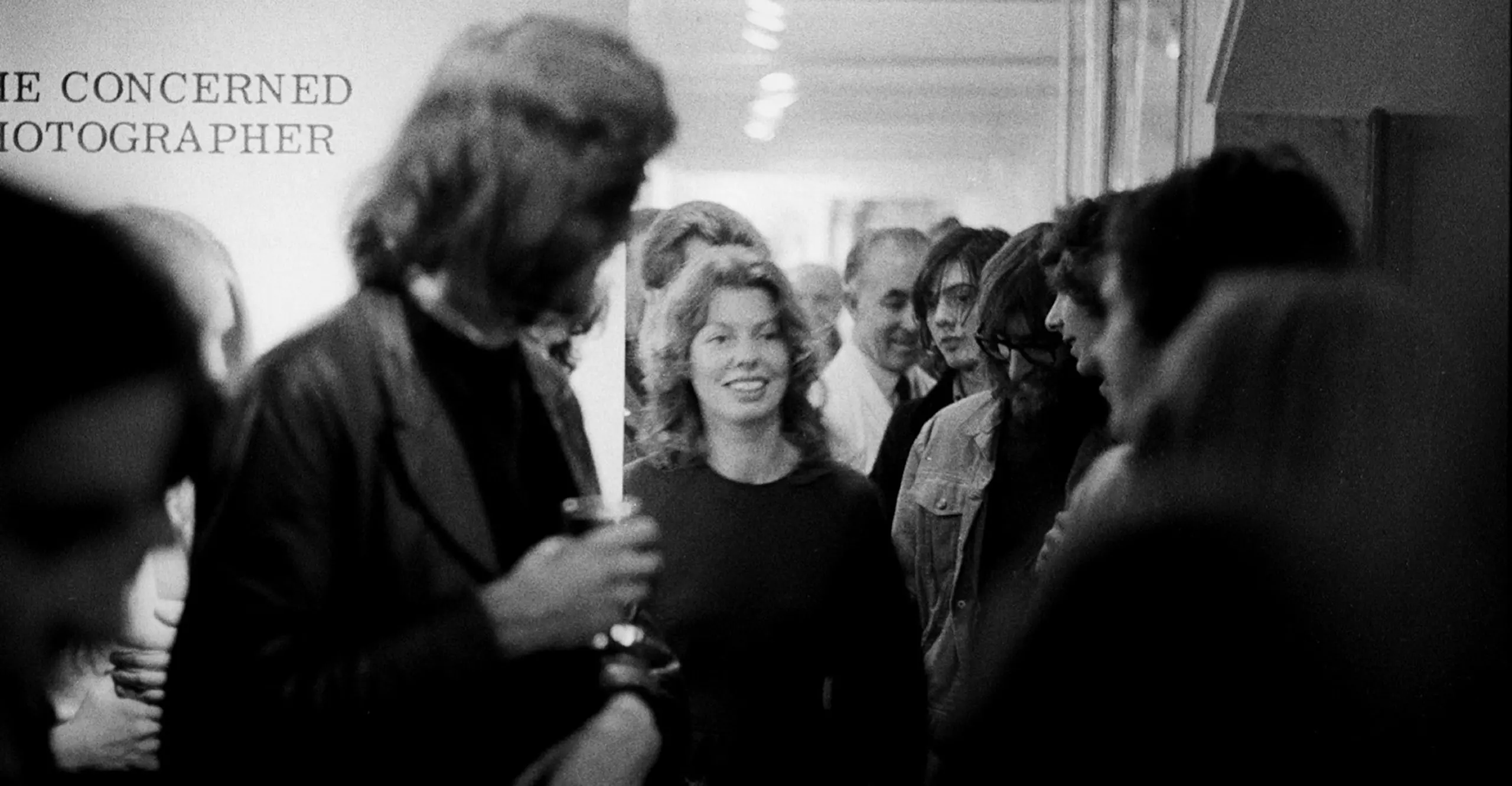 An image from the private view for The Concerned Photographer, the first exhibition at The Photographers' Gallery in 1971. Sue Davies is pictured in the middle of a large crowd. 