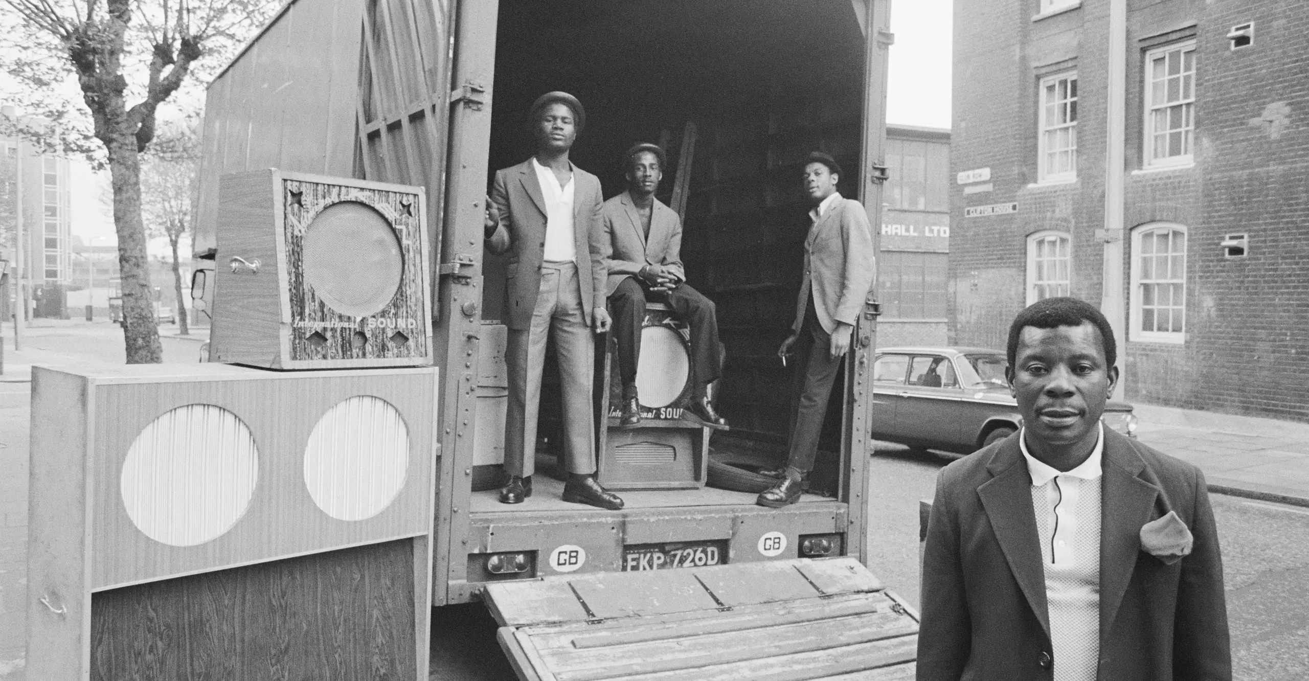 Four black men standing with a sound system