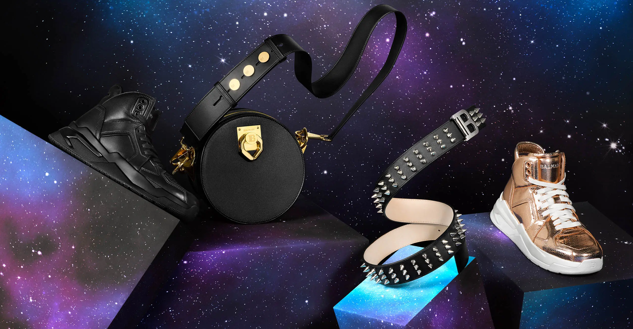 A black shoe, black bag, black belt and gold shoe shit on a space background.
