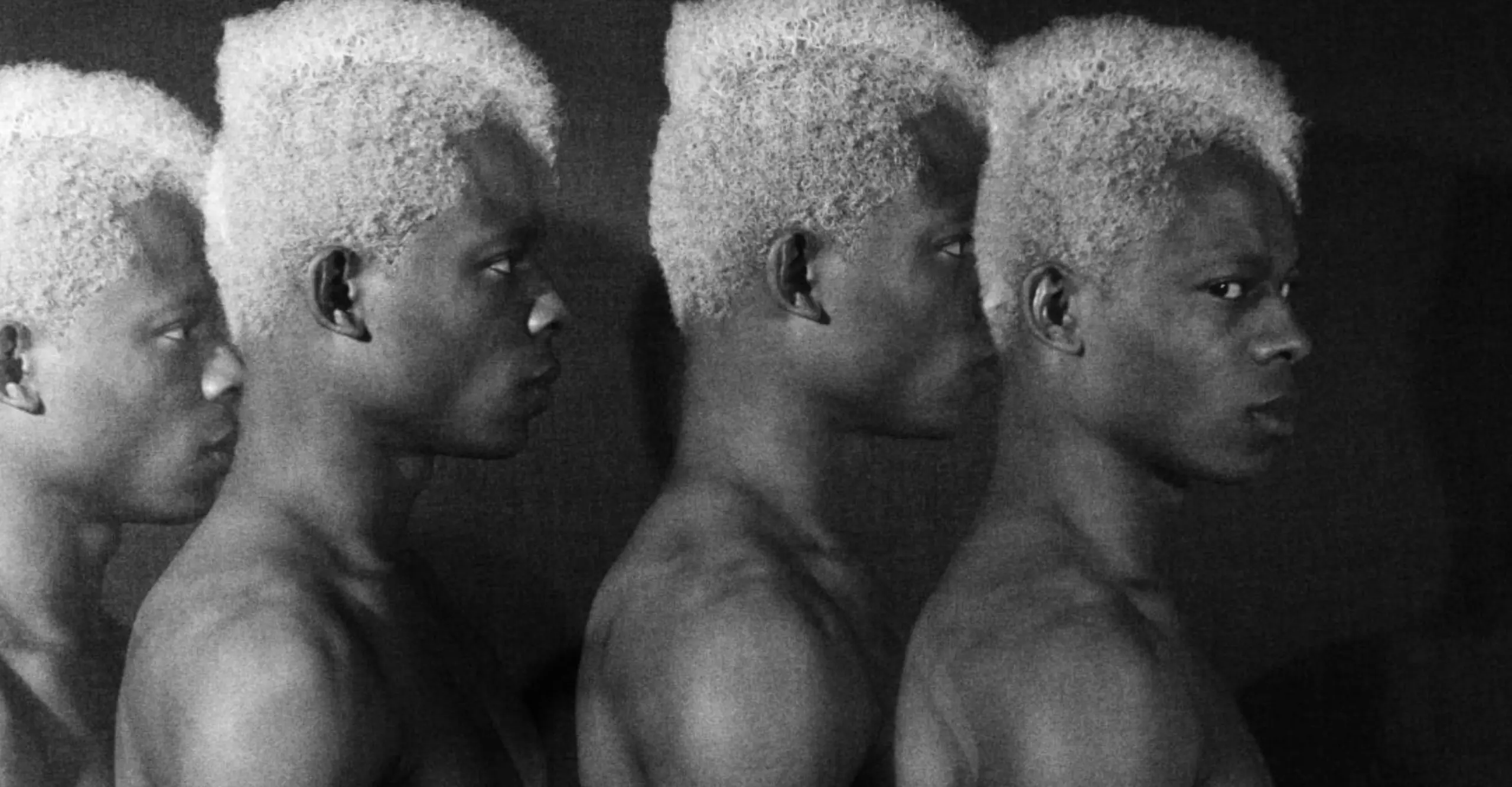 bw photograph of 4 people standing behind each other