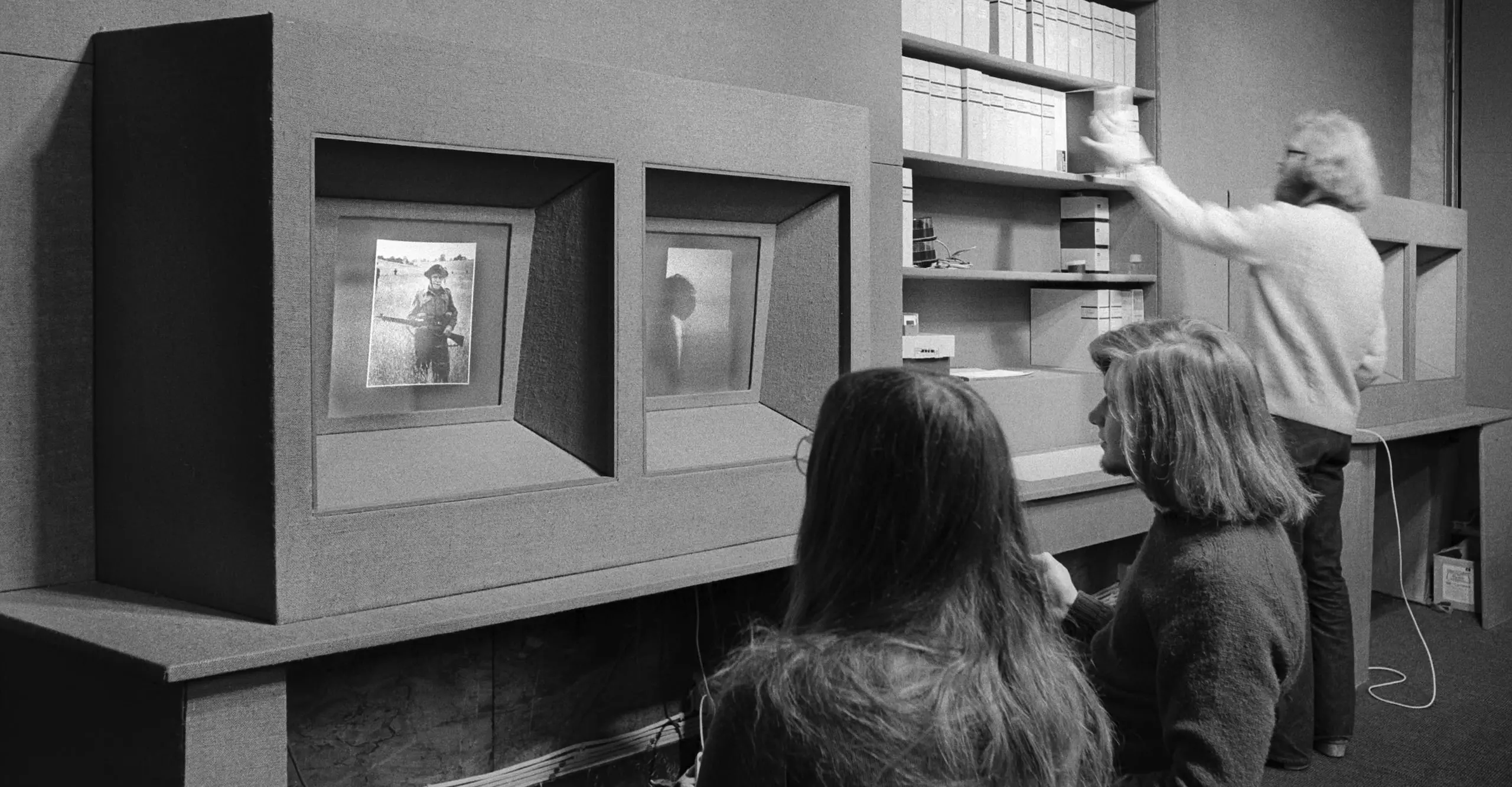 Black and white photograph of people in an archive room.