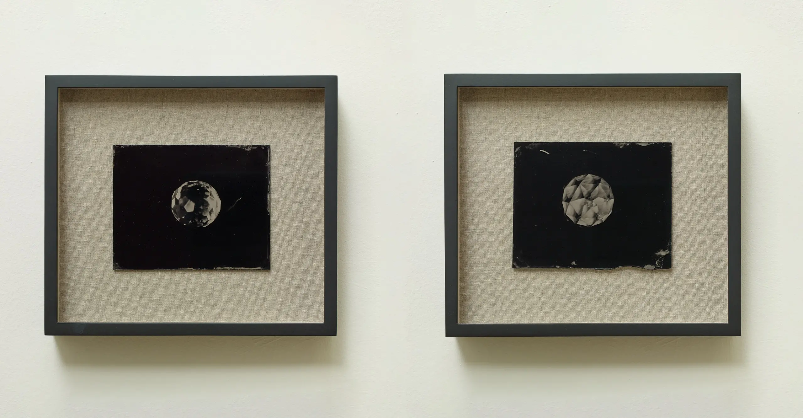 Install shot of two framed photographs of objects in space