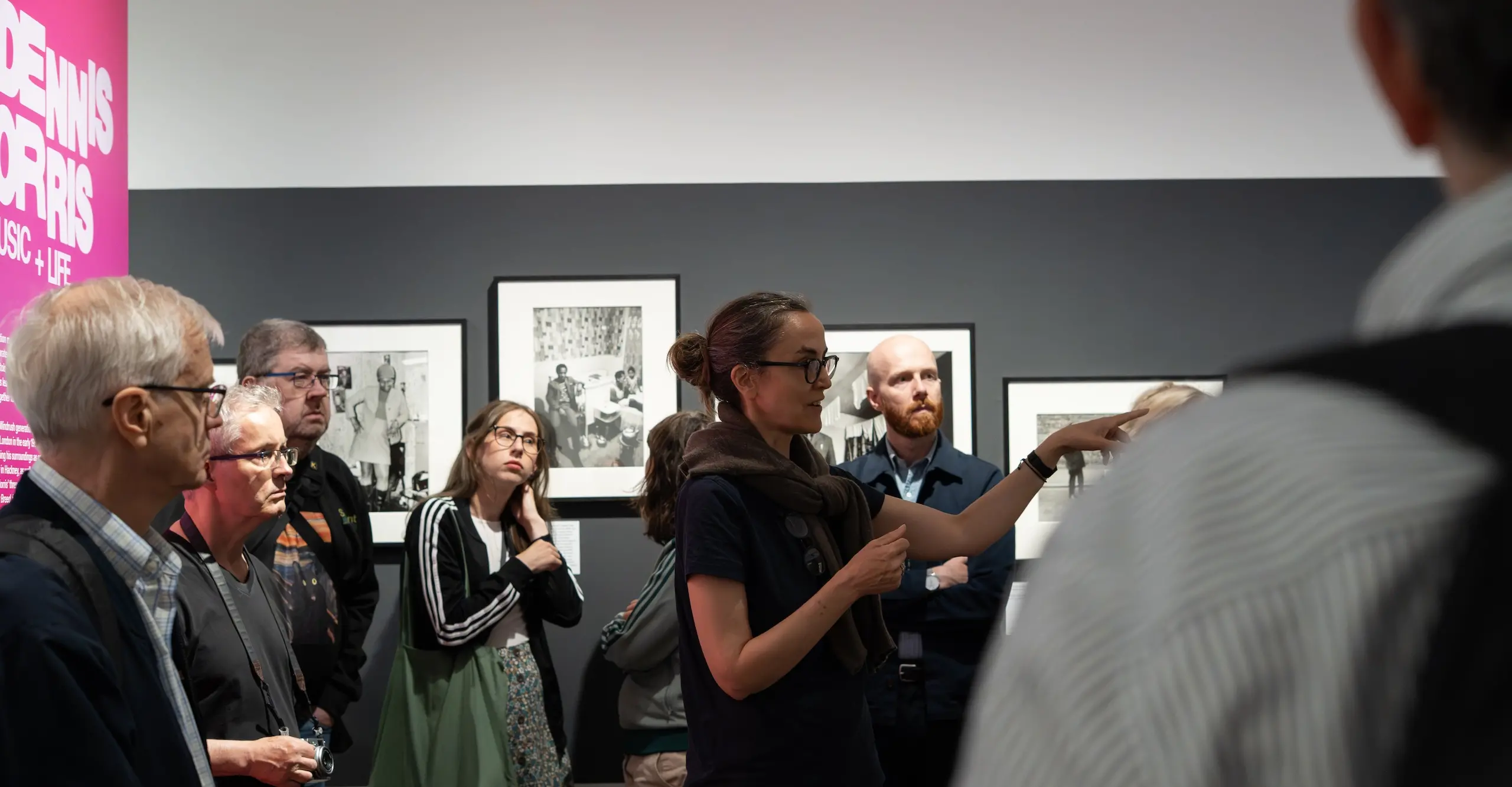 Crowd of people standing in Dennis Morris exhibition
