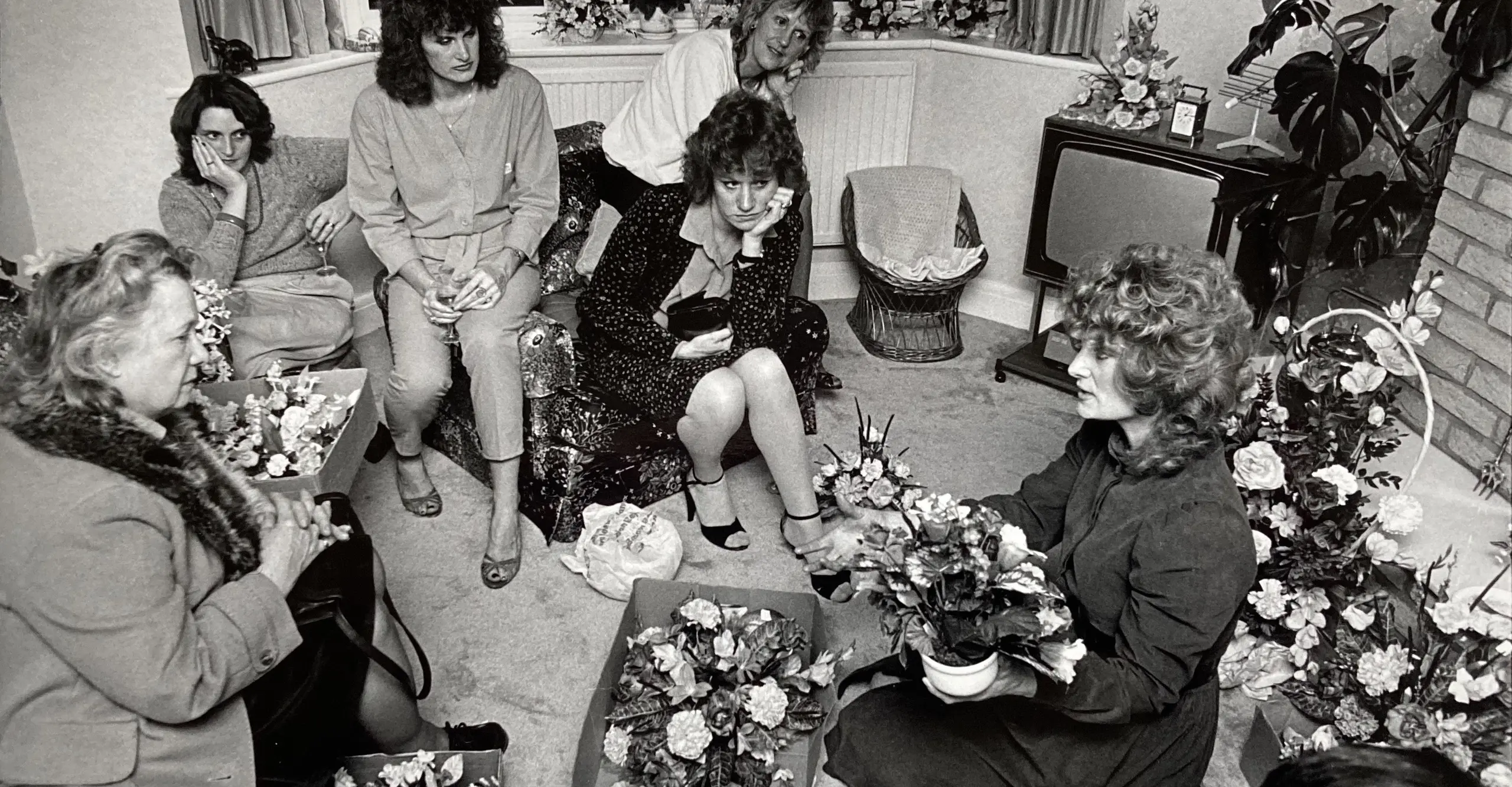 Women in a suburban living room discussing silk flower arranging