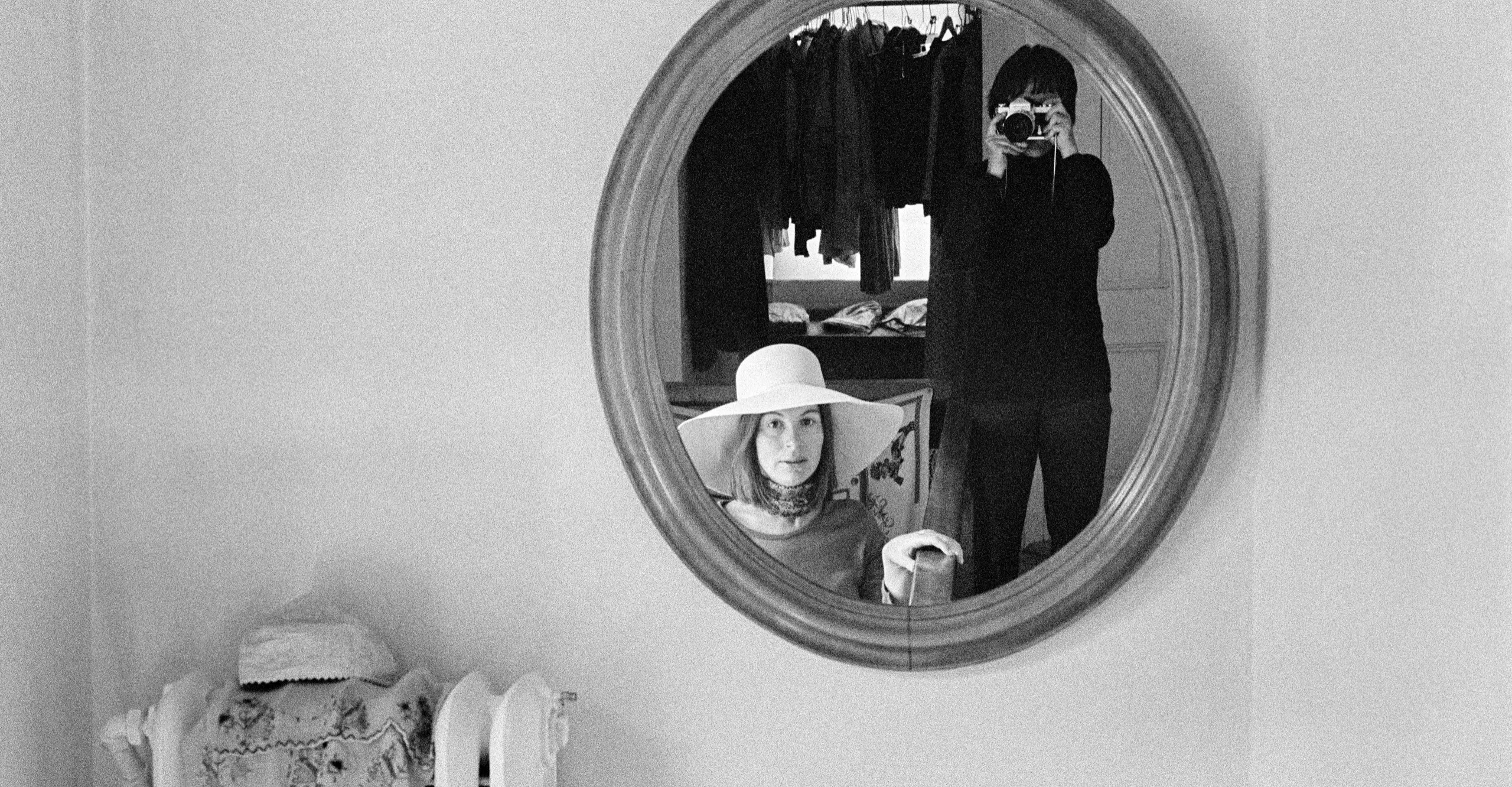 Black and white image of Evelyn Hofer's reflection in a round mirror