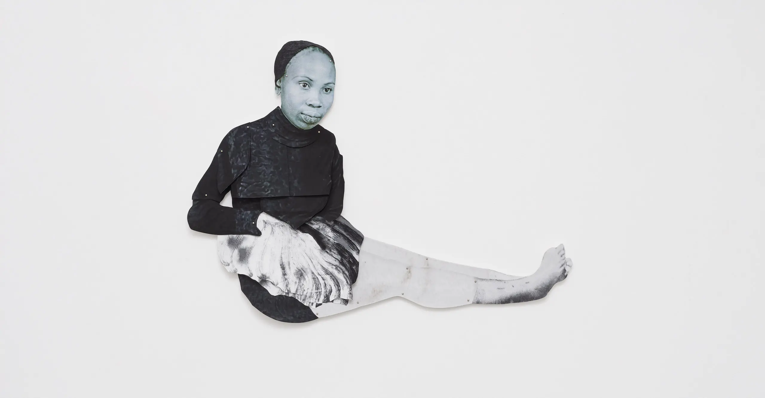 Black and white photo-based wall mounted collage of a seated Black woman.