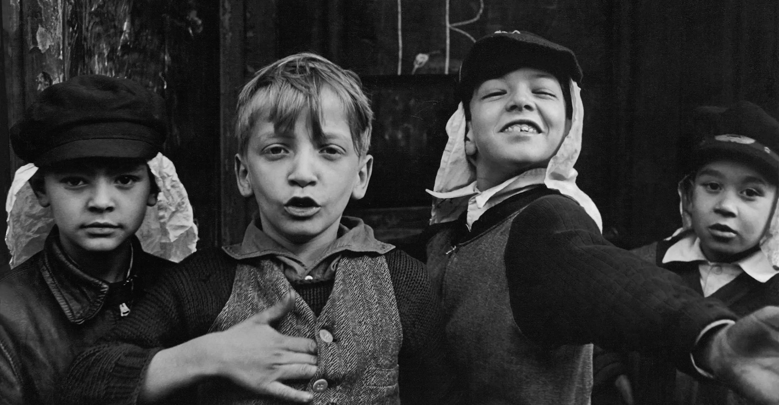 Black and white photograph showing head and shoulders of four boys aged about 8 years acting playfully for the camera.