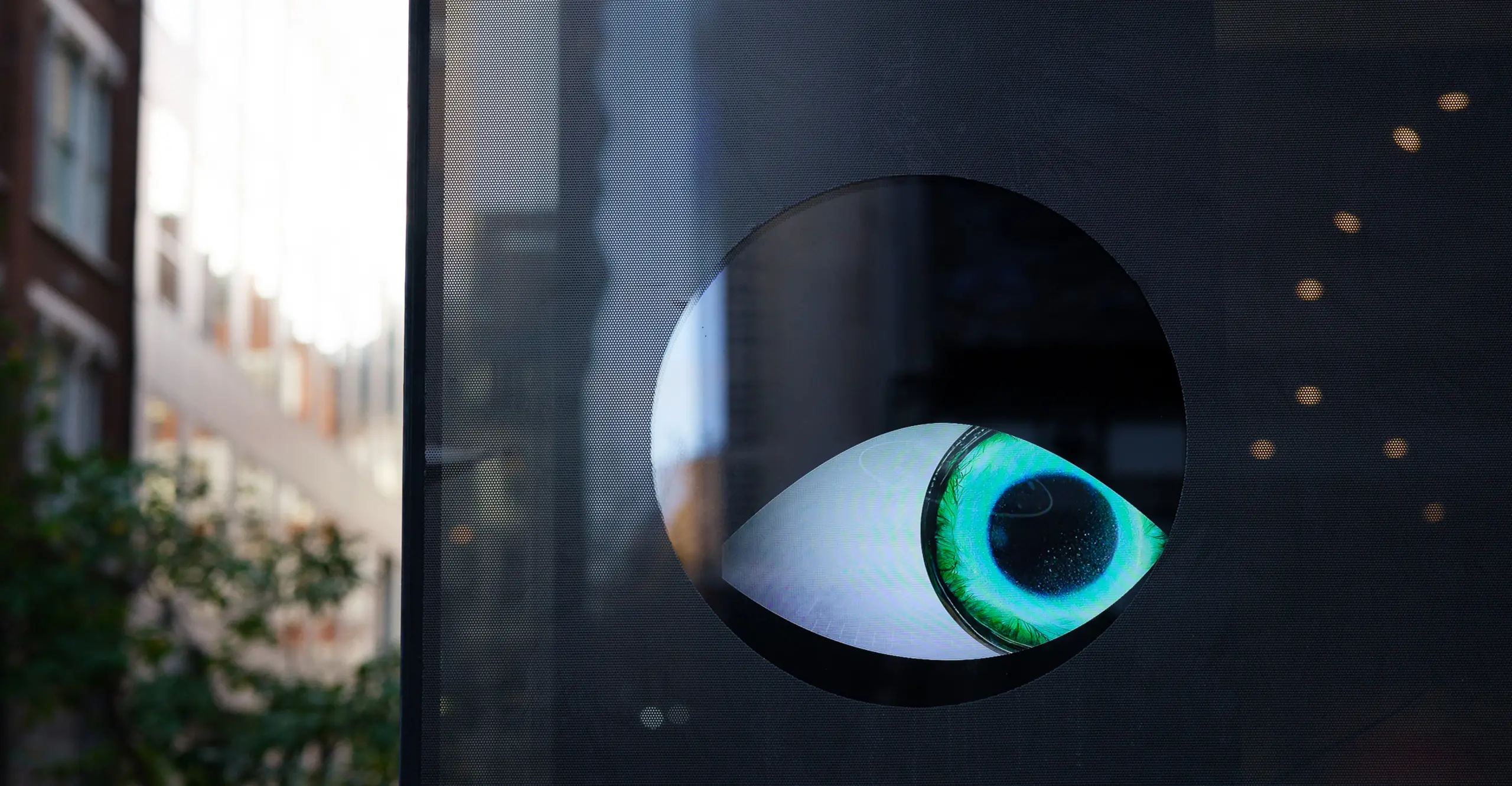 A large animated eye looks out of a dark window