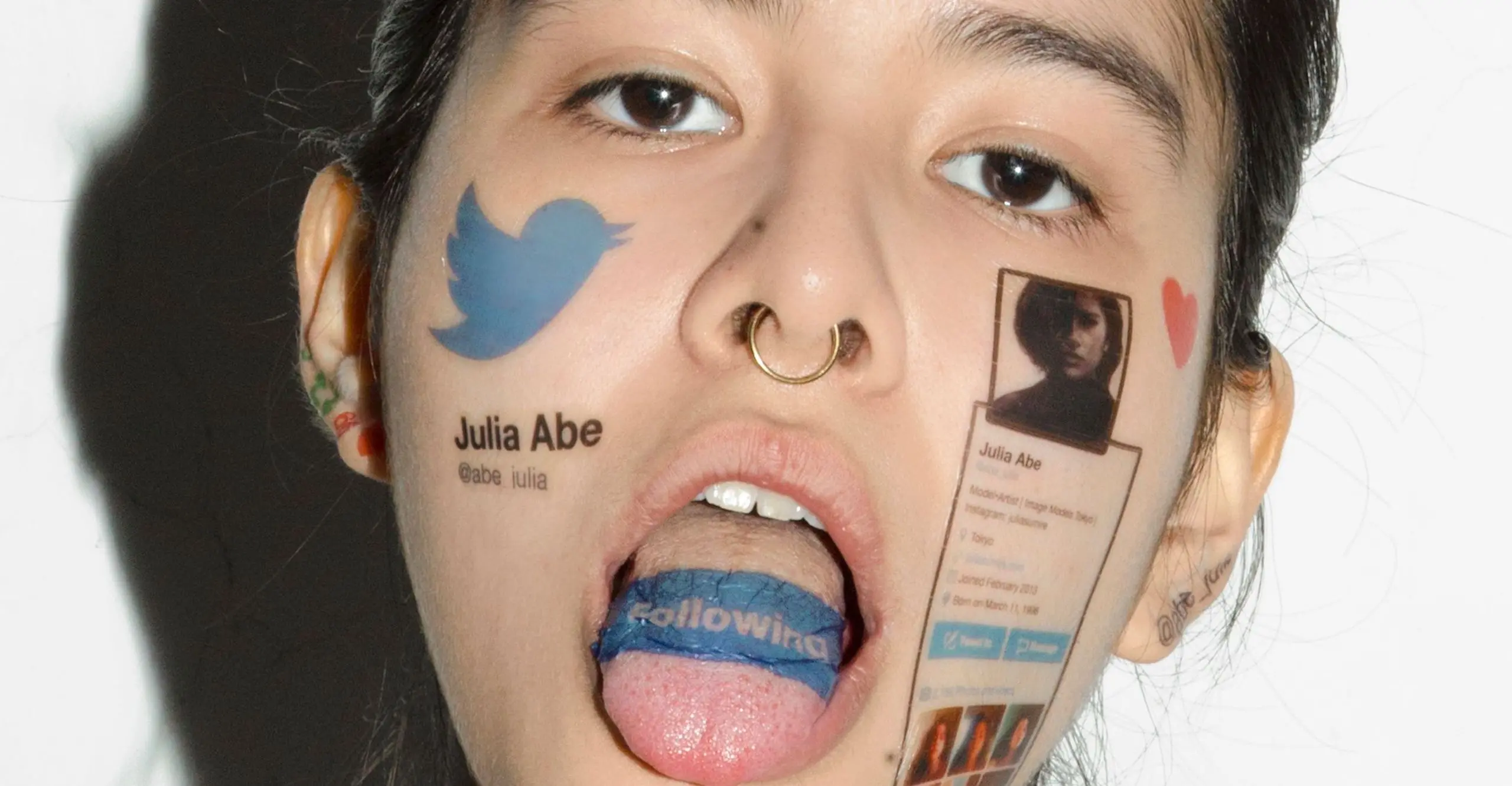Photo of a person's face covered in twitter icons and logos, including their tongue which they are sticking out.