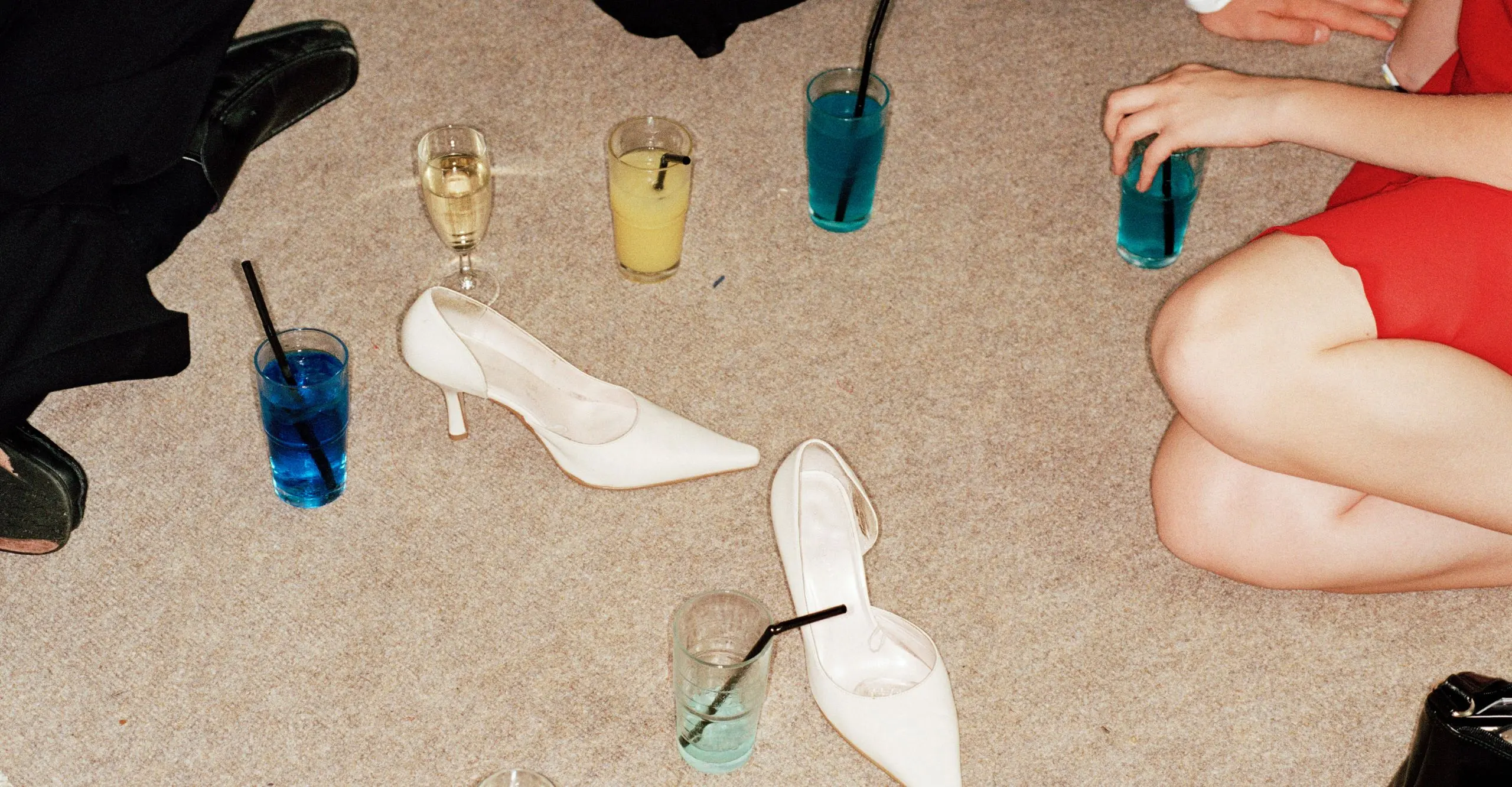 colour photography of people sitting on floor with shoes and glasses