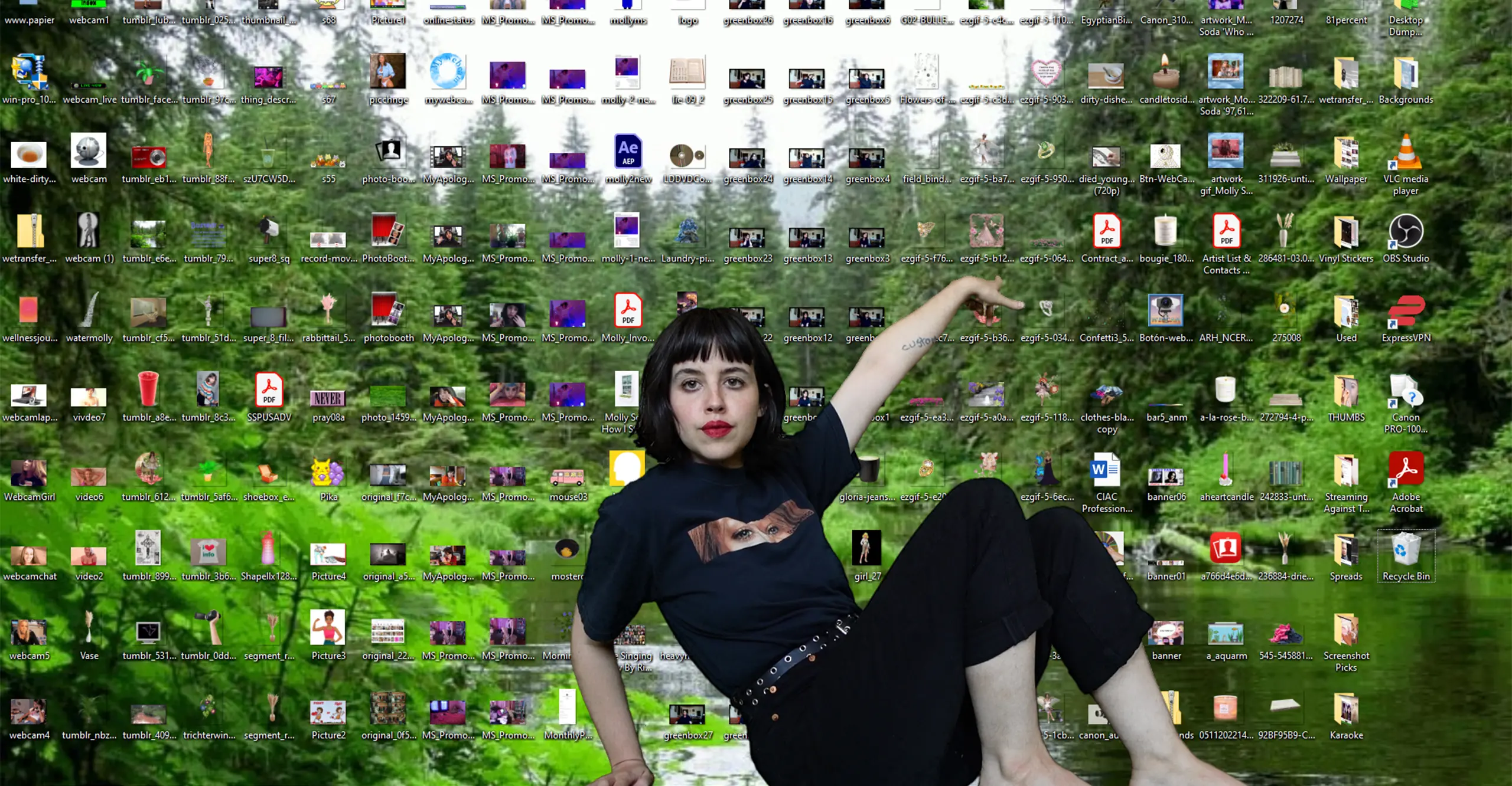 A woman facing the camera shows a screenshot of a computer desktop full of files