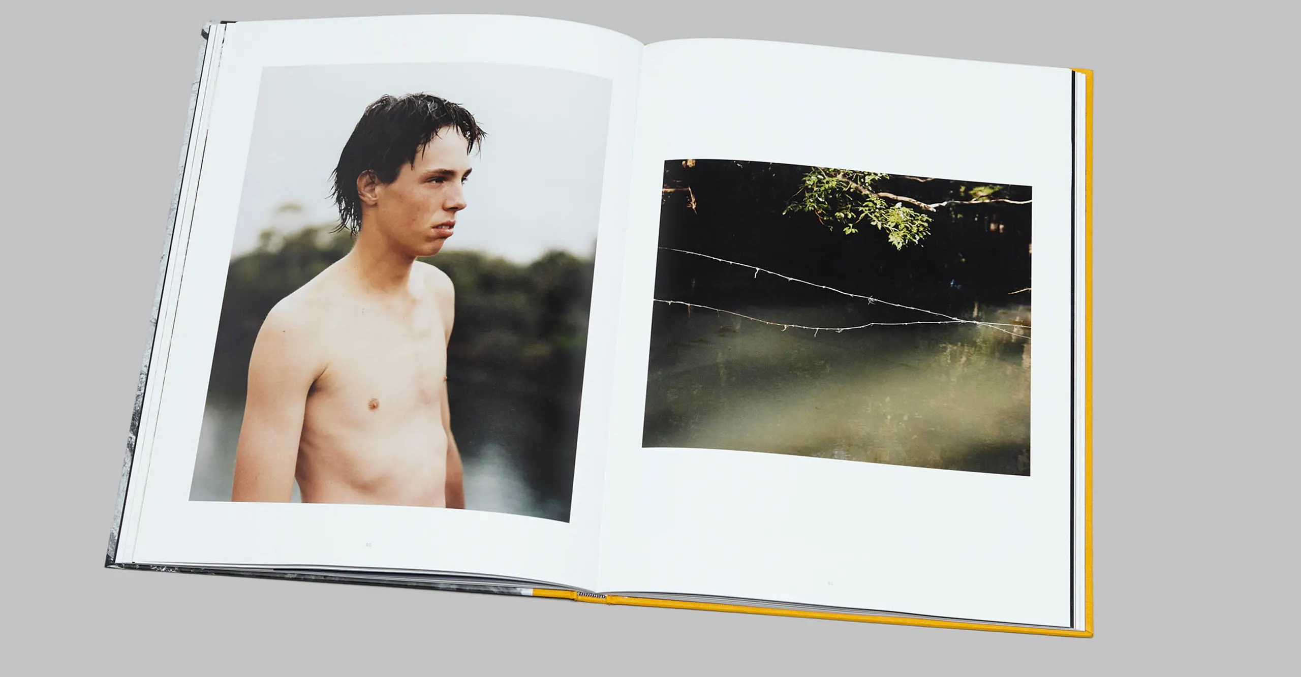 A photograph of a book laid out on a page with a portrait of a topless male.