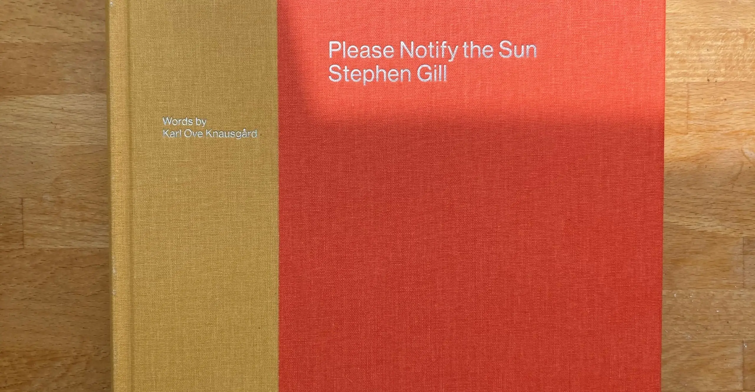 Book cover, fabric bound hardback. Beige/Orange spine, reddish orange cover. Reads "Please Notify the Sun, Stephen Gill."