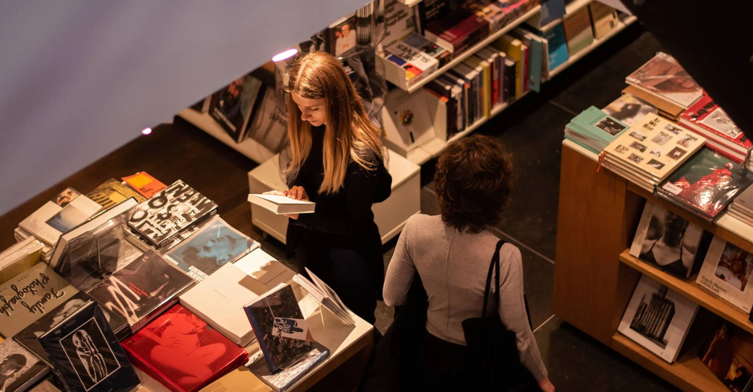 Colour photograph of two people looking at books in a bookshop