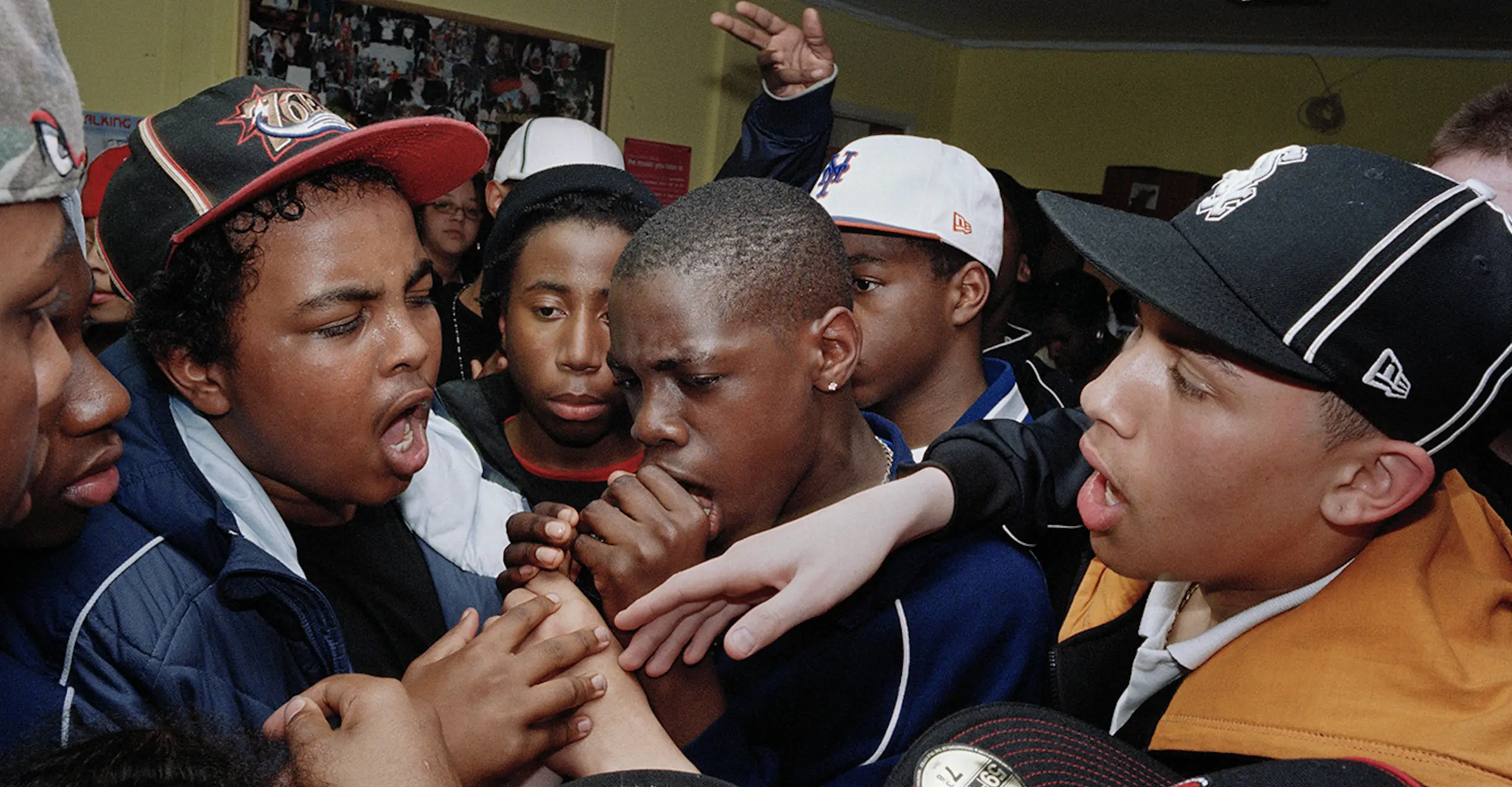 Photo of a group of boys rapping into a microphone. 