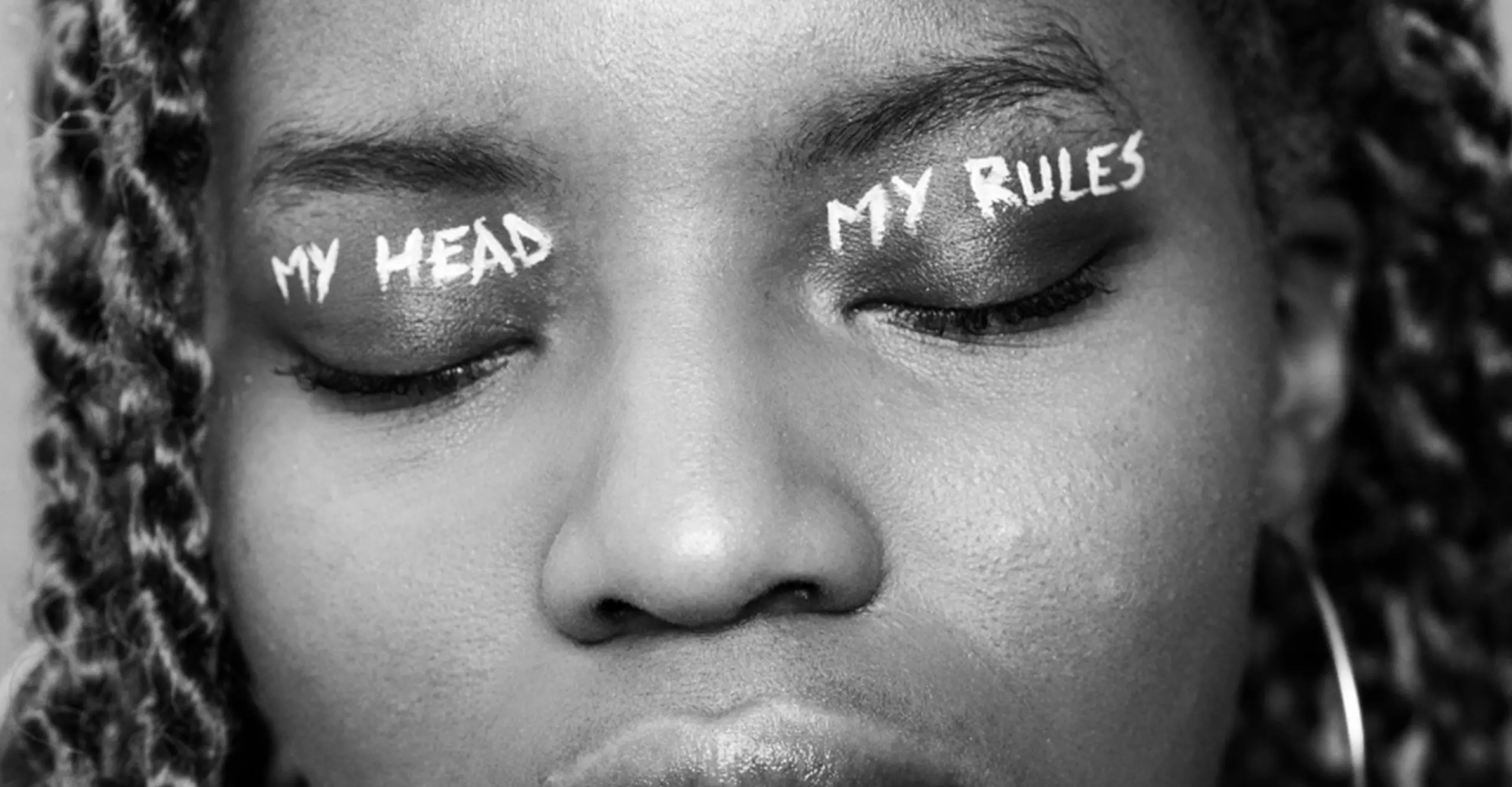 Black and white close up image of woman with eyes closed, with 'my head' written on right eyelid, and 'my rules' on left eyelid  