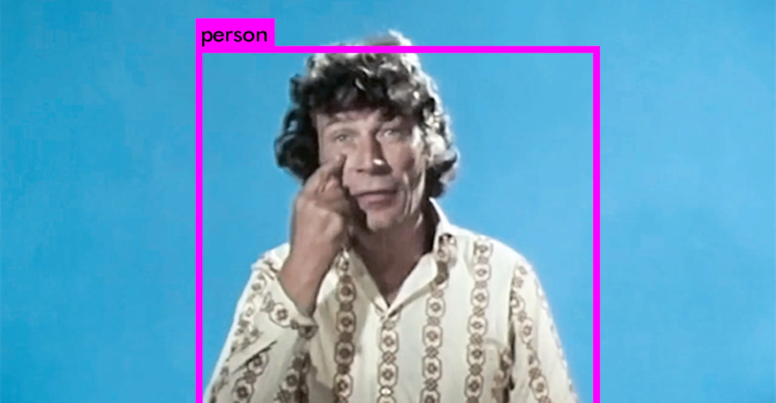 A person in front of a bright blue screen points at their eye, their head and shoulders are framed by a pink square with the word 'person' written at the top.