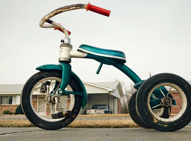 A child's tricycle on a suburban street.