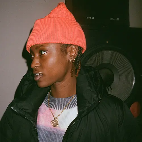Colour photograph of young person wearing orange beanie hat