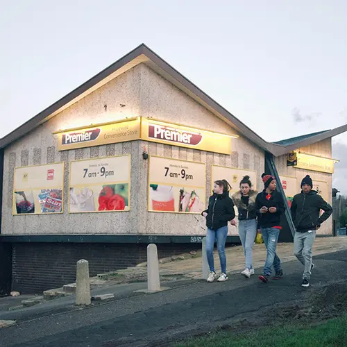 Outside view of shop with a group of young people walking outside