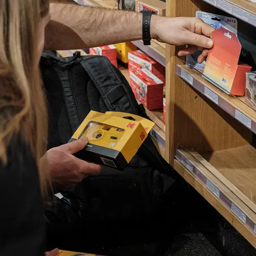 A close up of people browsing through cameras in a shop