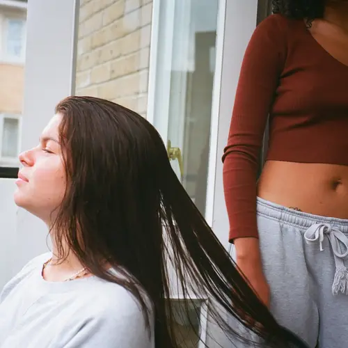 A photo of a person with long hair on a balcony.