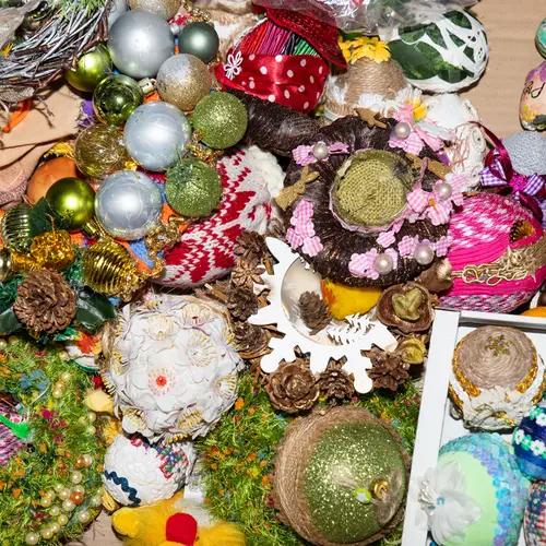 A close up of a cluttered table top covered in handmaid festive decorations.