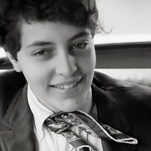 A portrait of a person with dark hair smiling at the camera.