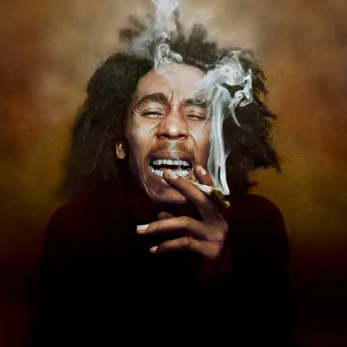 Colour photograph of Bob Marley with a spliff between his fingers.