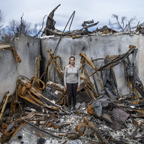 Photograph of a person in the middle of a burnt building