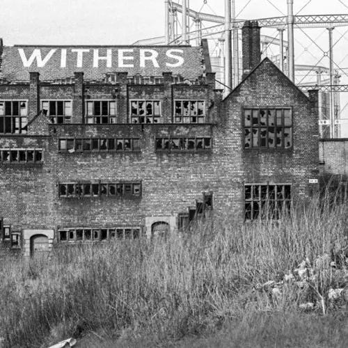 Black and white photograph of a derelict building in an urban landscape