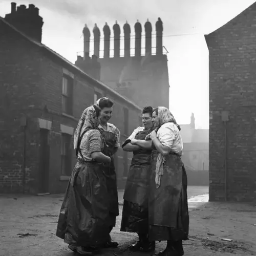 Black and white photograph of a small group of women talking in the street
