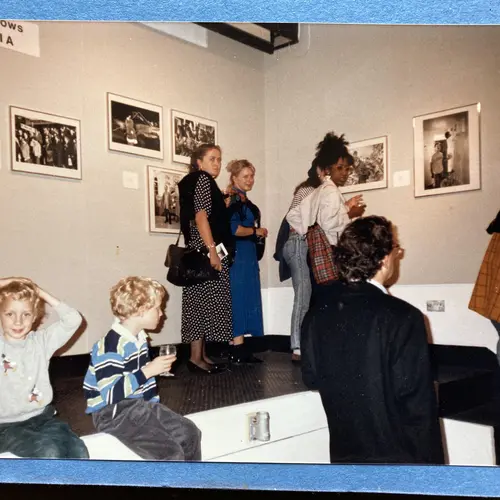 General view of guests at the Suburbia exhibition, including the artist’s two sons on the left. © Georgie Meadows