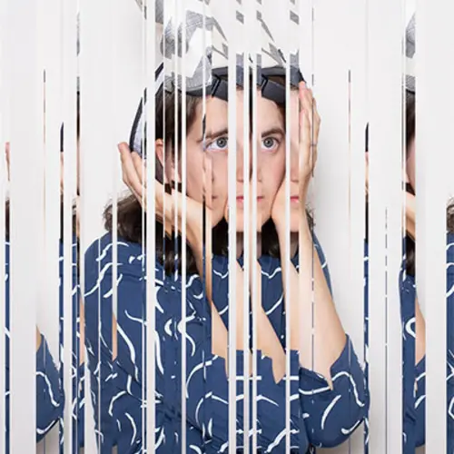 A glitched portrait of a woman holding a headpiece