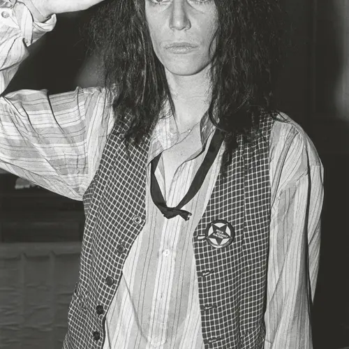 Black and white photograph of Patti Smith posing with her hand against her head.