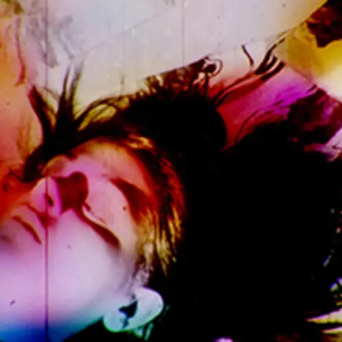 A colourful and very contrasted portrait of a person lying down on the floor 