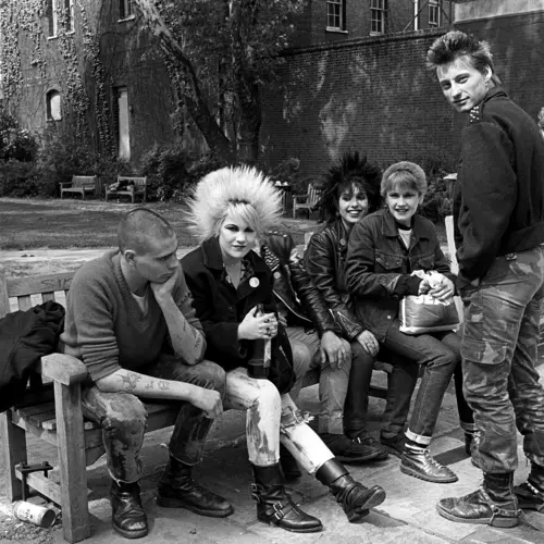 photograph of a group of punks sitting on an outdoor bench