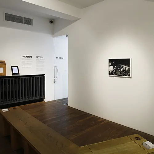 Framed black and white photograph with a dog legged bench in front of it.