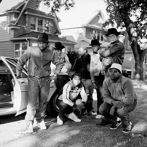 black and white photograph of run dmc posing on a street in queens