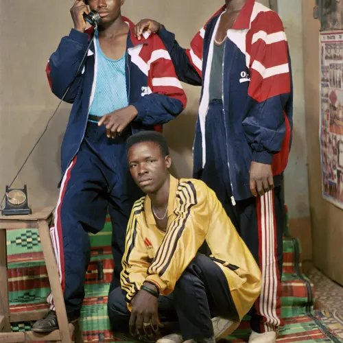 Colour photograph of three young men  wearing shell tracksuits and posing for the camera.