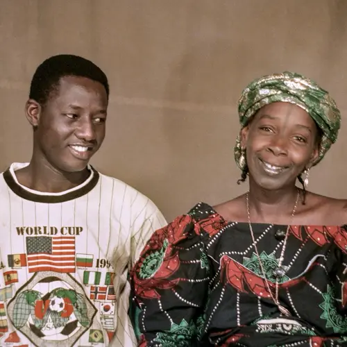 Colour photograph of a man and a woman sitting side-by-side.