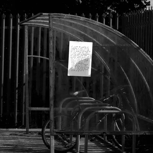 A photograph of writing stuck to a bus stop.
