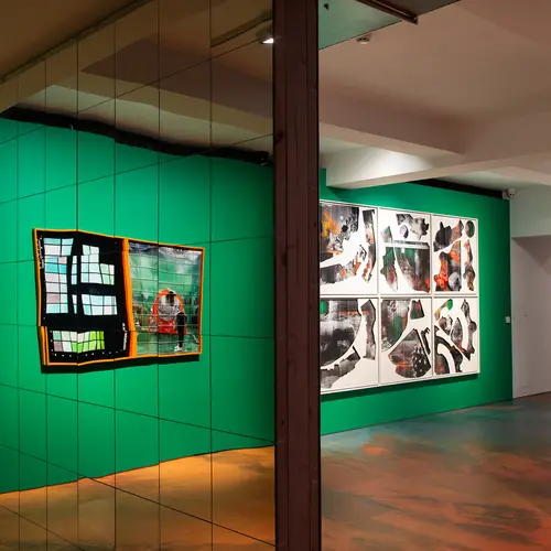 An install shot from the Felicity Hammond V3 Model Collapse exhibition. Large framed image of a collapsing generative images are hung on display facing a mirrored wall..