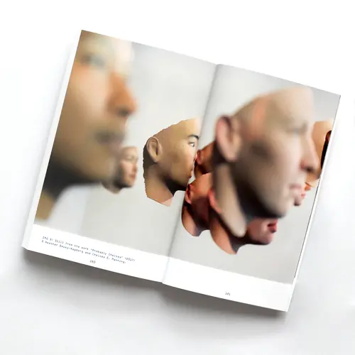 a book open with a picture of sculptures of faces