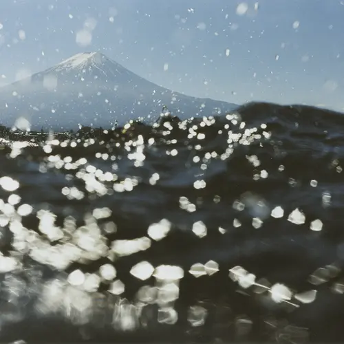 Colour photograph of Mount Fuji in the distance, taken from above the water